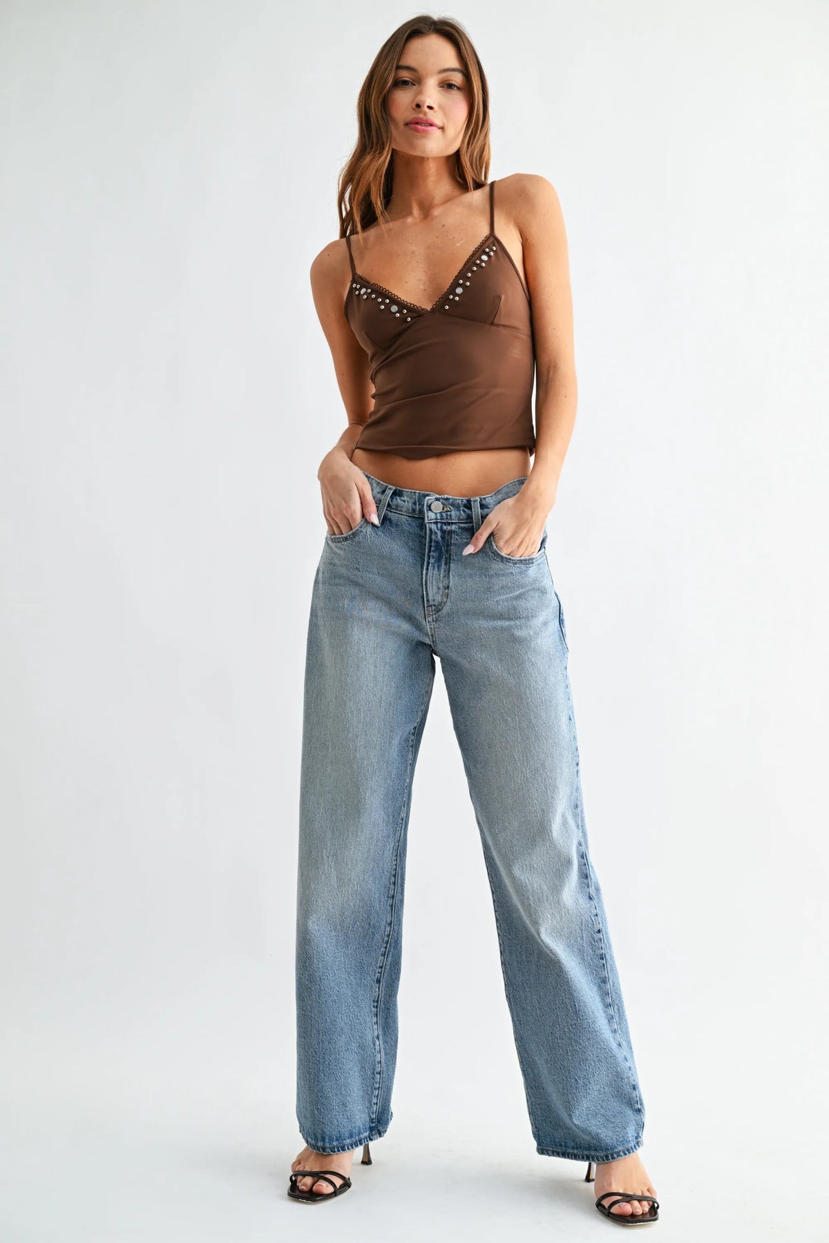 Brown studded spaghetti strap crop top paired with mid rise lightweight relaxed straight denim jeans
