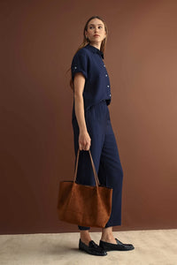 Brown suede tote bag with long handles paired with elastic waist crop pants for casual and stylish wear