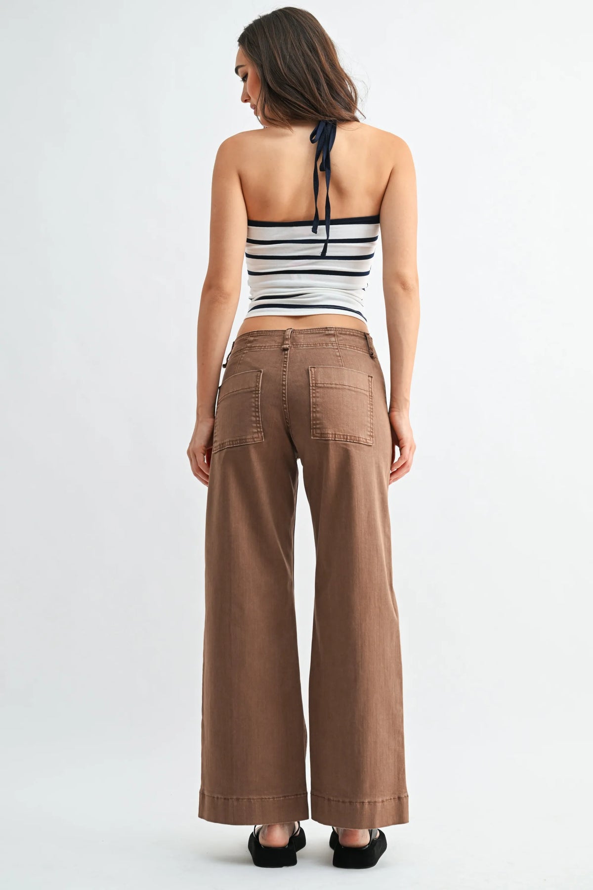 Brown mid rise twill wide leg trousers with relaxed fit and visible back pockets shown from the back side