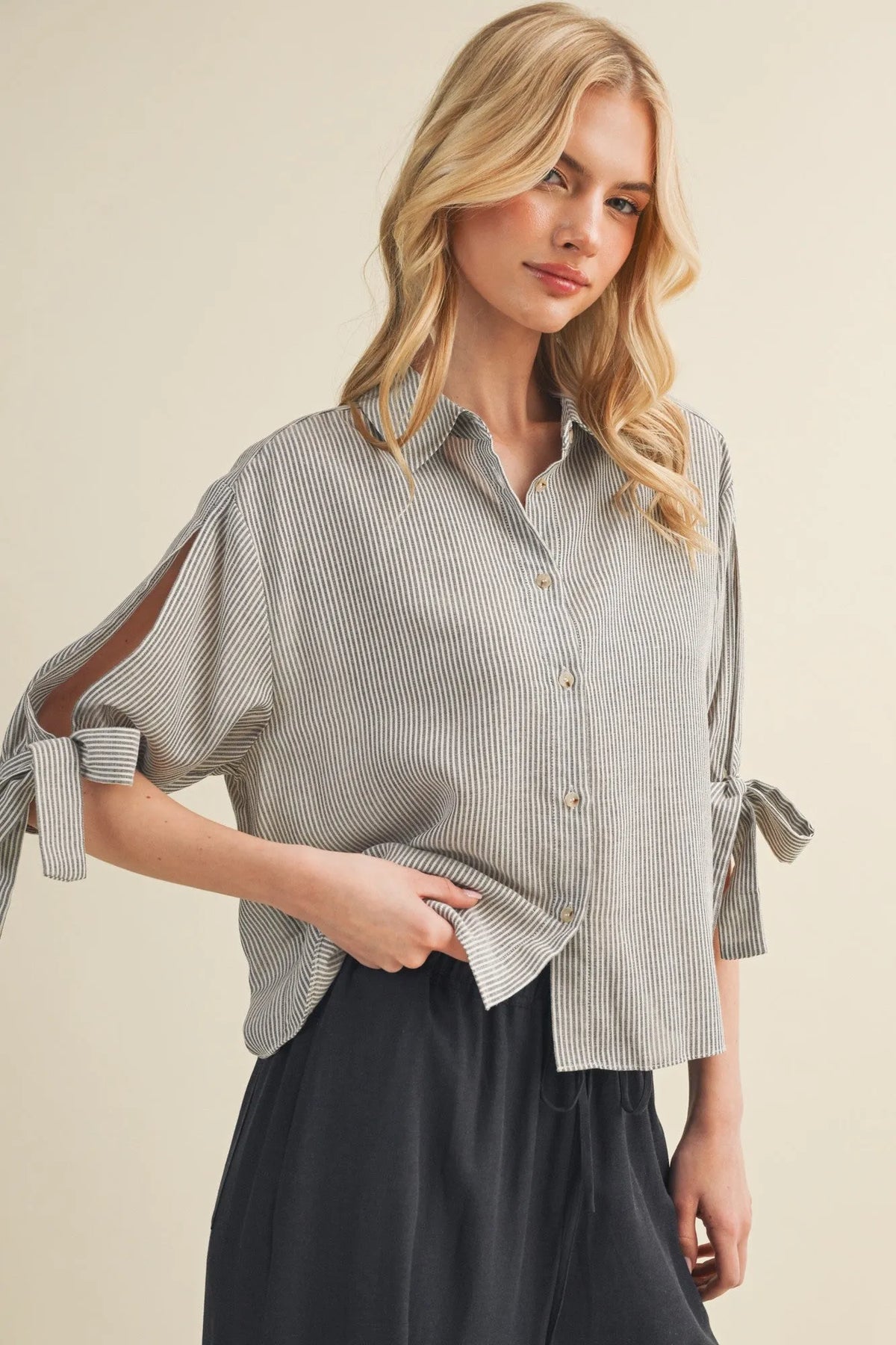 A soft gray and white vertical striped tie cuff button front top with loose fit and tied cuffs