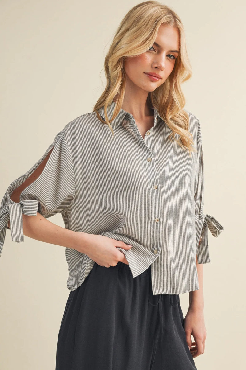 A soft gray and white vertical striped tie cuff button front top with loose fit and tied cuffs