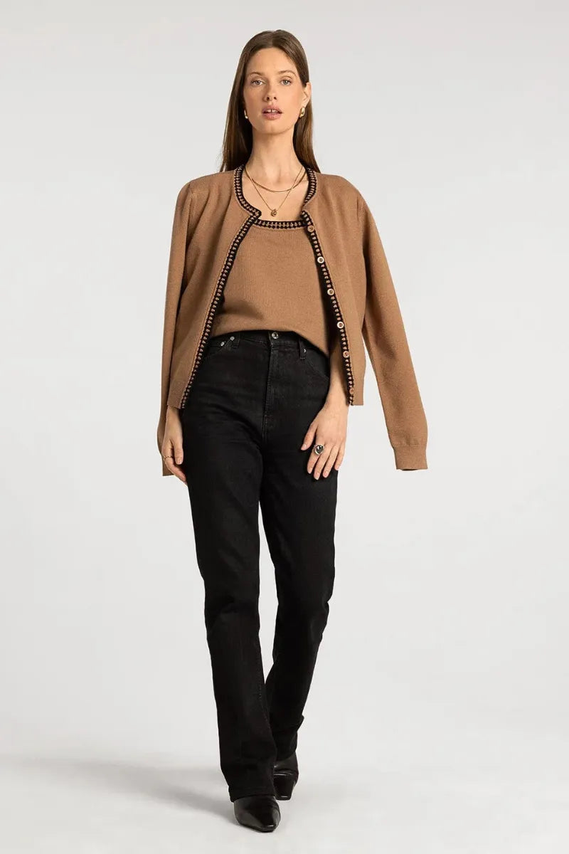 A camel-colored cardigan with black trim and decorative buttons paired with supply brittania tank