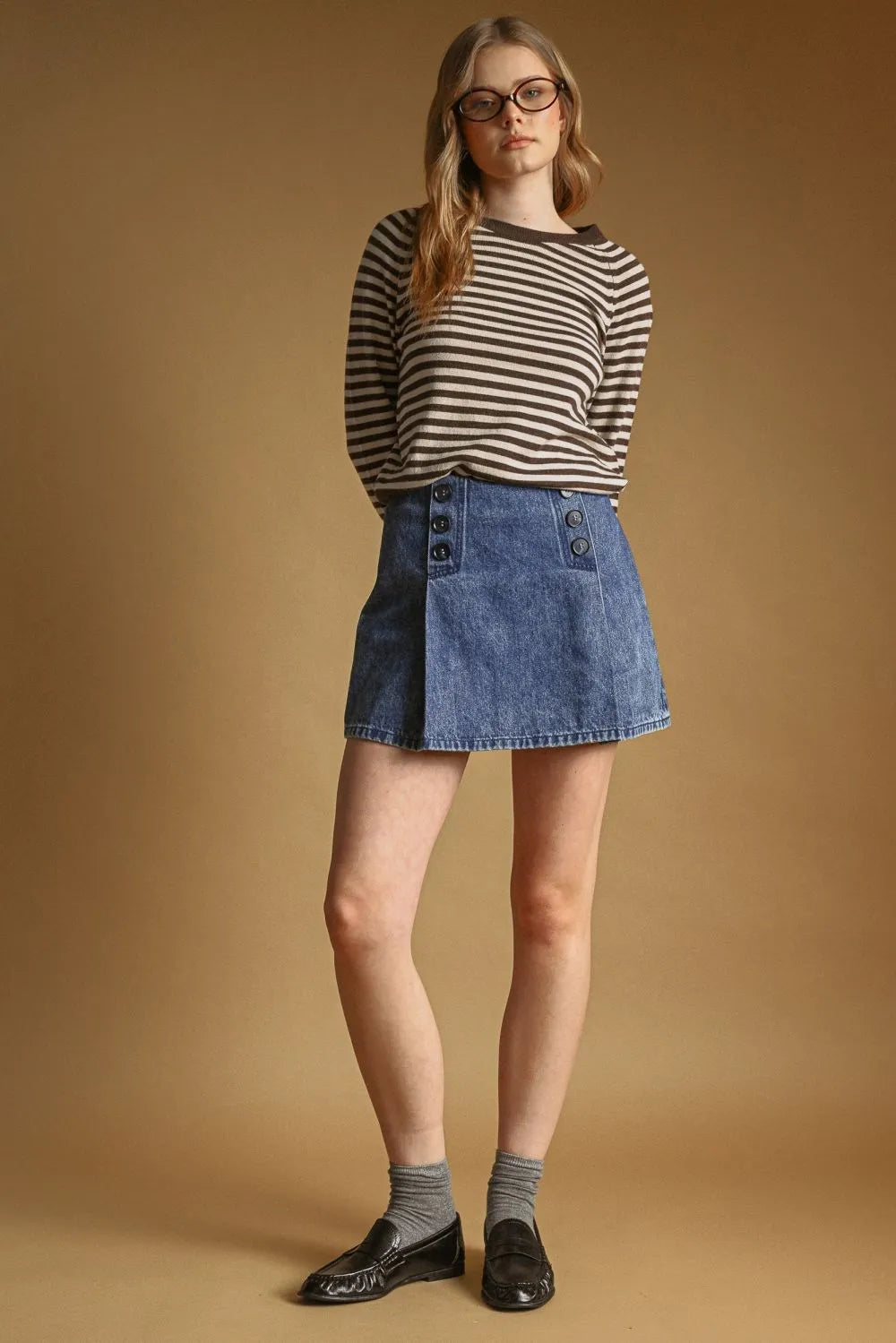 A classic blue denim mini skirt with front button detail paired with a striped round neck sweater