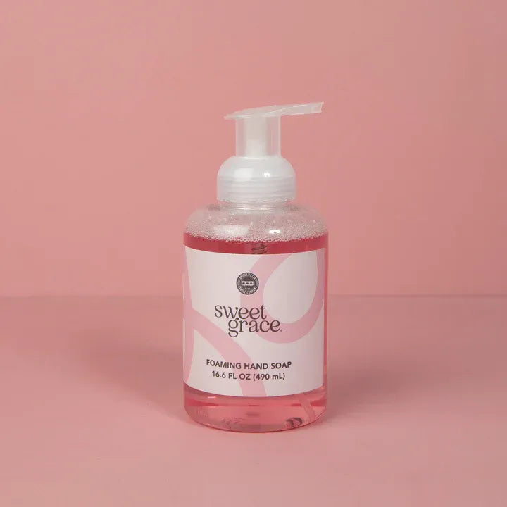 A clear bottle of sweet grace foaming hand soap with pink liquid and a white pump dispenser with minimalist label