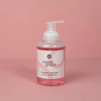 A clear bottle of sweet grace foaming hand soap with pink liquid and a white pump dispenser with minimalist label