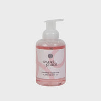A clear plastic bottle of sweet grace foaming hand soap with a white pump and pink foaming soap inside