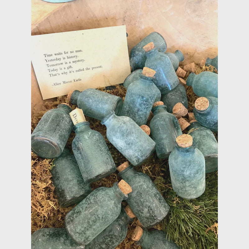 Vintage frosted green mini bottle with cork lid in mossy bedding