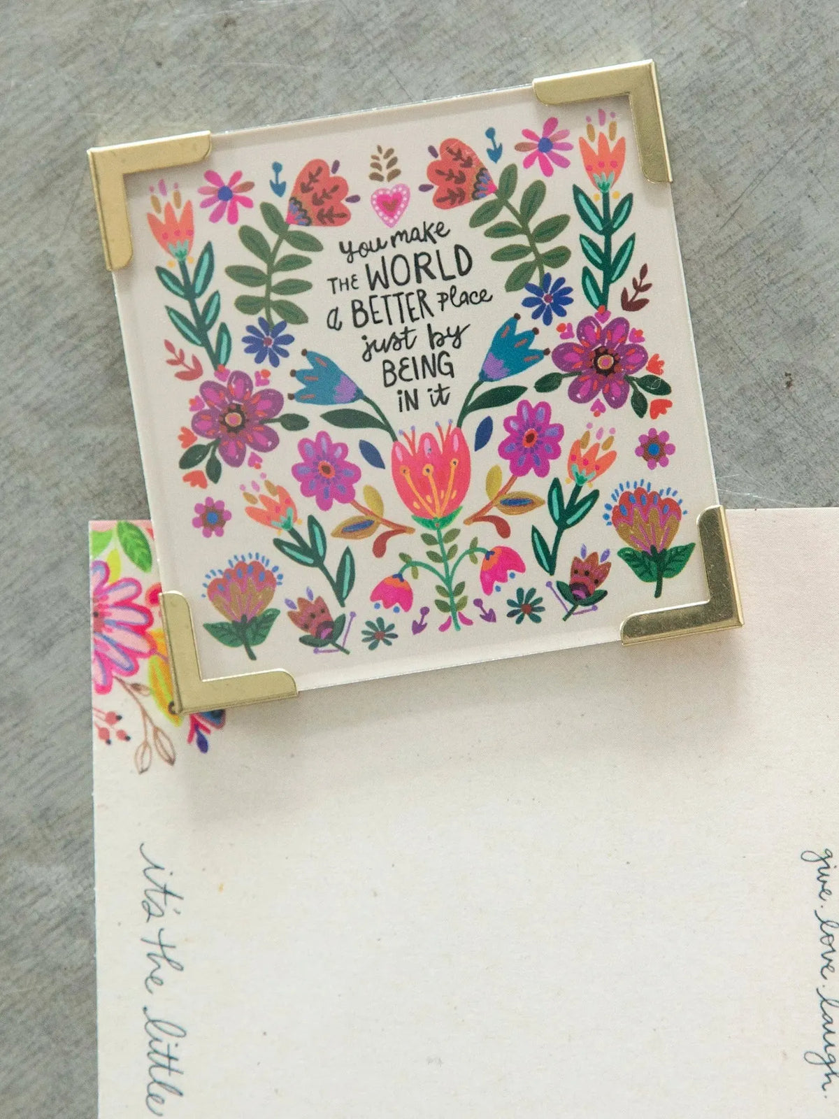 Corner magnet with colorful floral design and gold accents featuring you make the world better for shop daisy fans