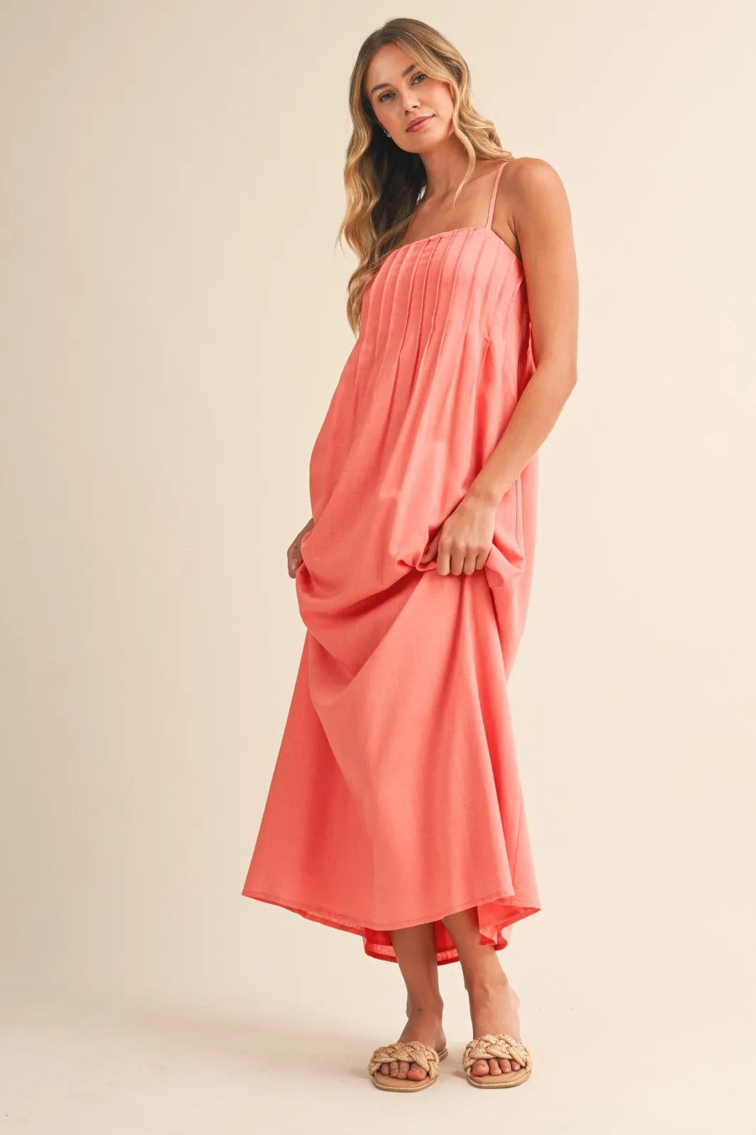 Coral pintuck detailed strappy maxi dress with thin spaghetti straps and a high-low hemline for elegant occasions