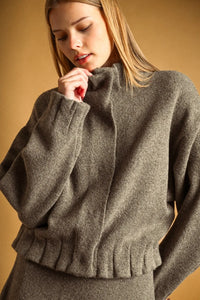 A cozy heather gray wool-blend sweater with high neck button closure and ruffled hem ideal for layering