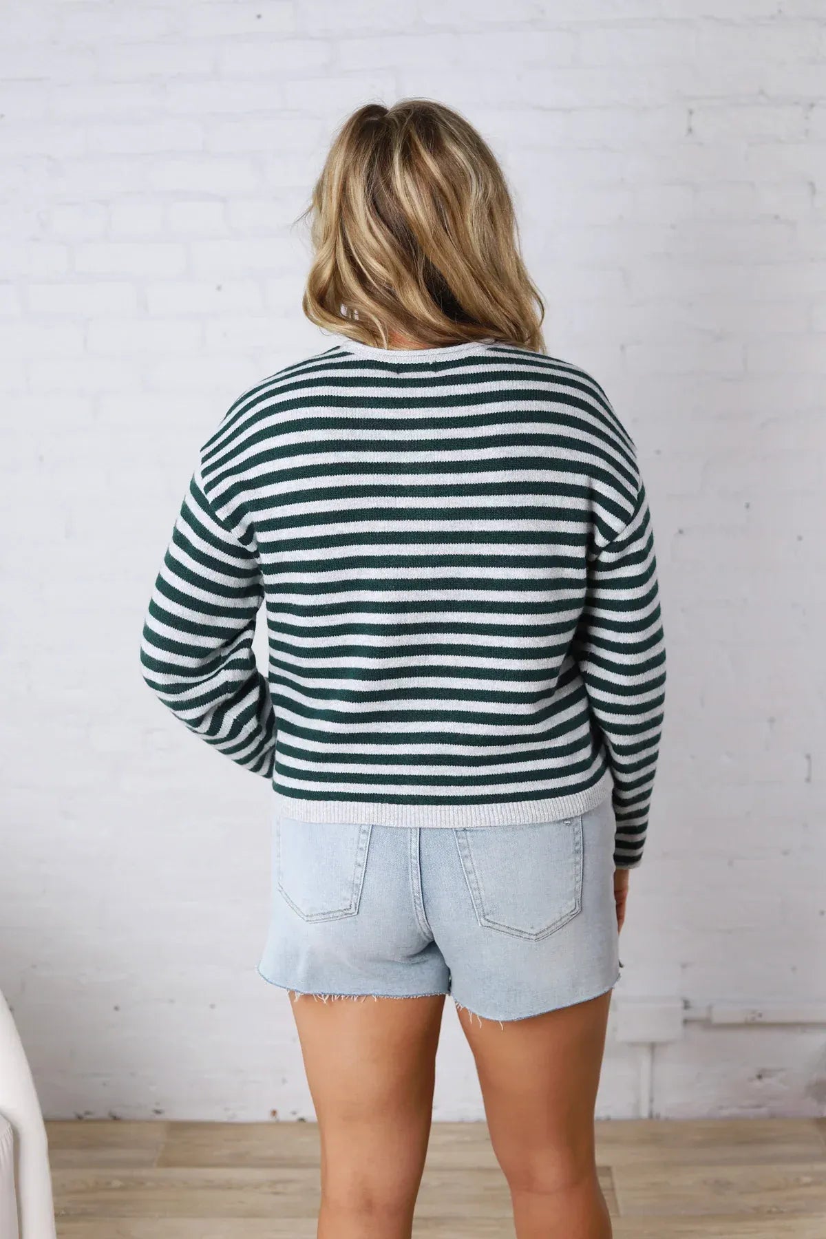 A cozy supply dover button front cardigan in dark green and white knit fabric with horizontal stripes and long sleeves