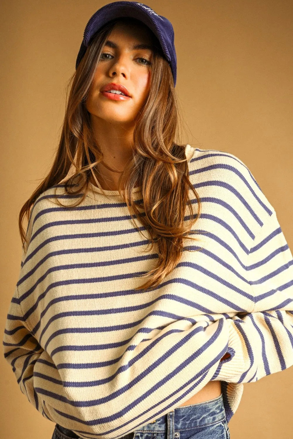 A cozy off-white and navy blue striped long sleeve knit sweater with a relaxed fit for casual wear