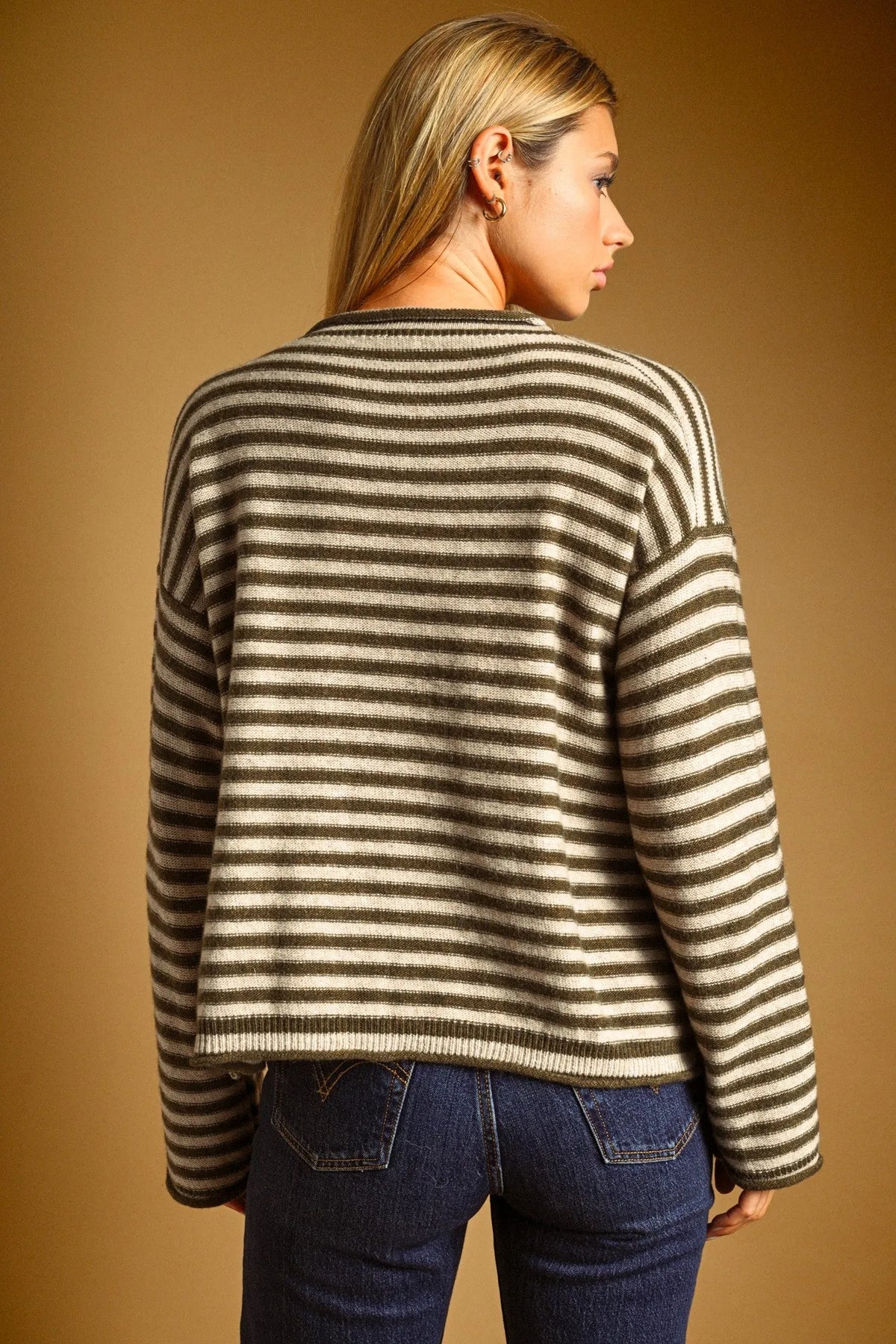A cozy oversized sweater with striped pattern rolled neck detail in olive green and cream for casual wear