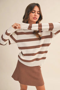 A cozy ribbed knit striped round neck relaxed sweater in cream and brown with horizontal stripes