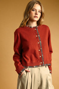 A cozy rust-red knit cardigan with plaid contrasted button front and wooden buttons for stylish layering