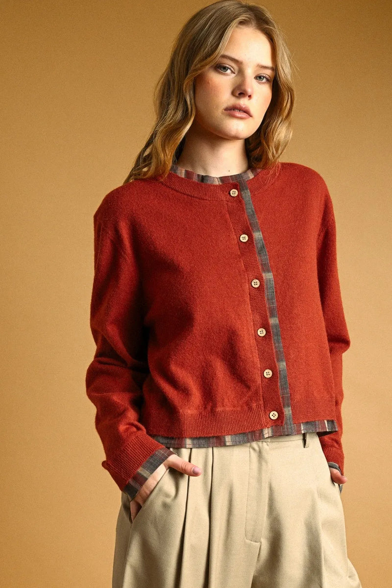 A cozy rust-red knit cardigan with plaid contrasted button front and wooden buttons for stylish layering