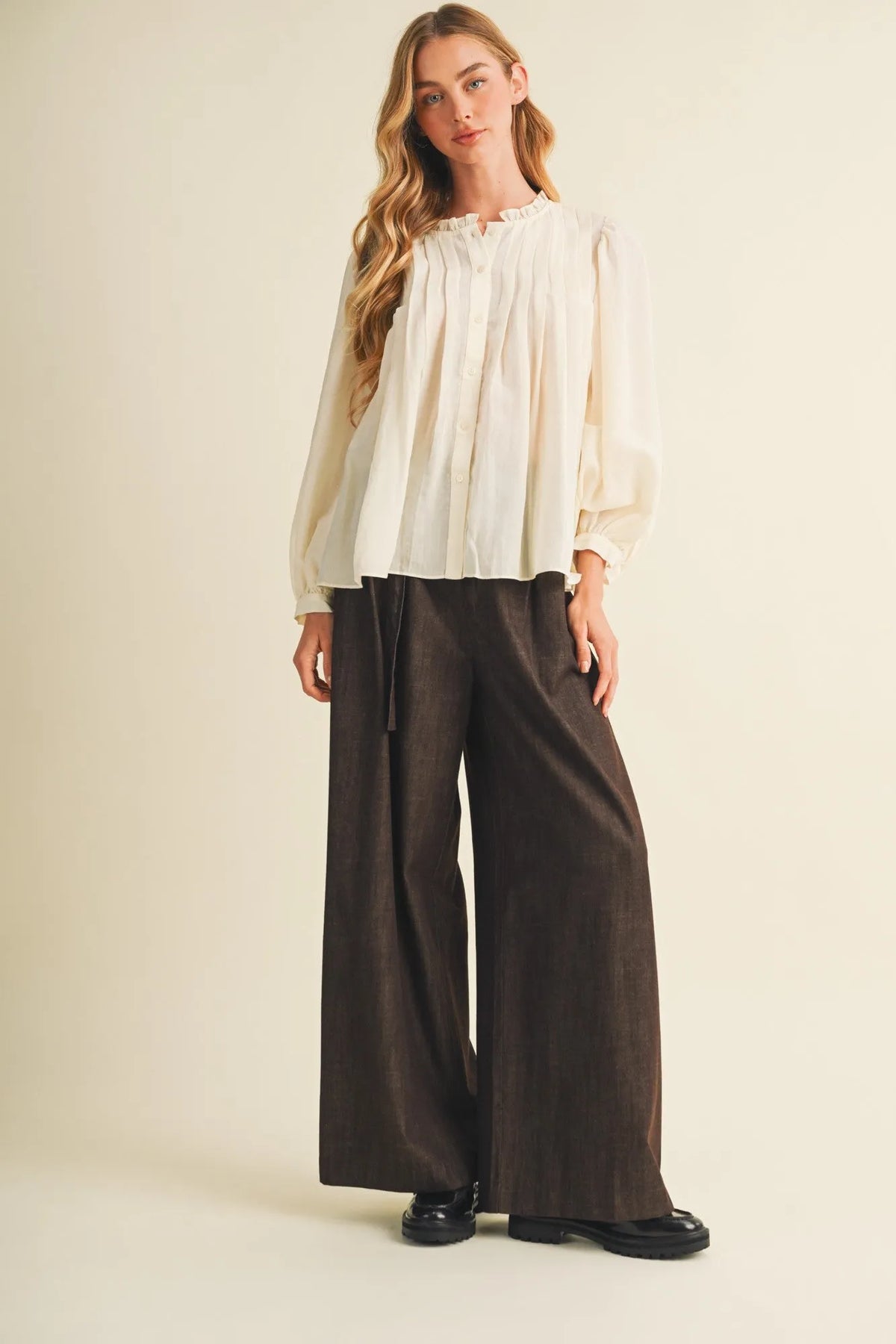 Cream-colored loose-fitting blouse with pintuck bib ruffle collar and long sleeves in a lightweight fabric