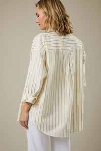 Cream-colored stripe classic button down shirt with thin brown stripes and rolled-up sleeves with gold buttons