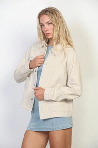Cream-colored garment washed corduroy chore jacket with button closures and flap pockets in washed corduroy fabric