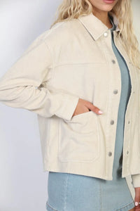 Cream-colored garment washed corduroy chore jacket with button-up front and two patch pockets in washed corduroy fabric