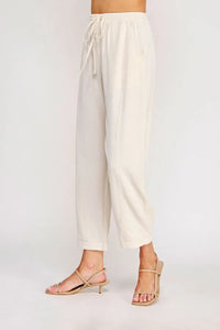 Cream-colored rayon linen blend relaxed tapered pants with elastic waistband and drawstring for casual comfort