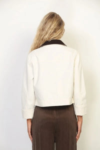 Cream-colored garment faded wash canvas barn jacket with contrasting black collar and rolled-up sleeves