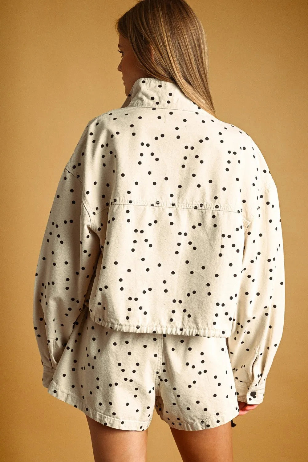 Cream-colored denim polka dot high neck jacket with matching shorts featuring black polka dot pattern