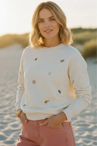 Cream-colored Thread & Supply road trip sweatshirt with embroidered animal motifs