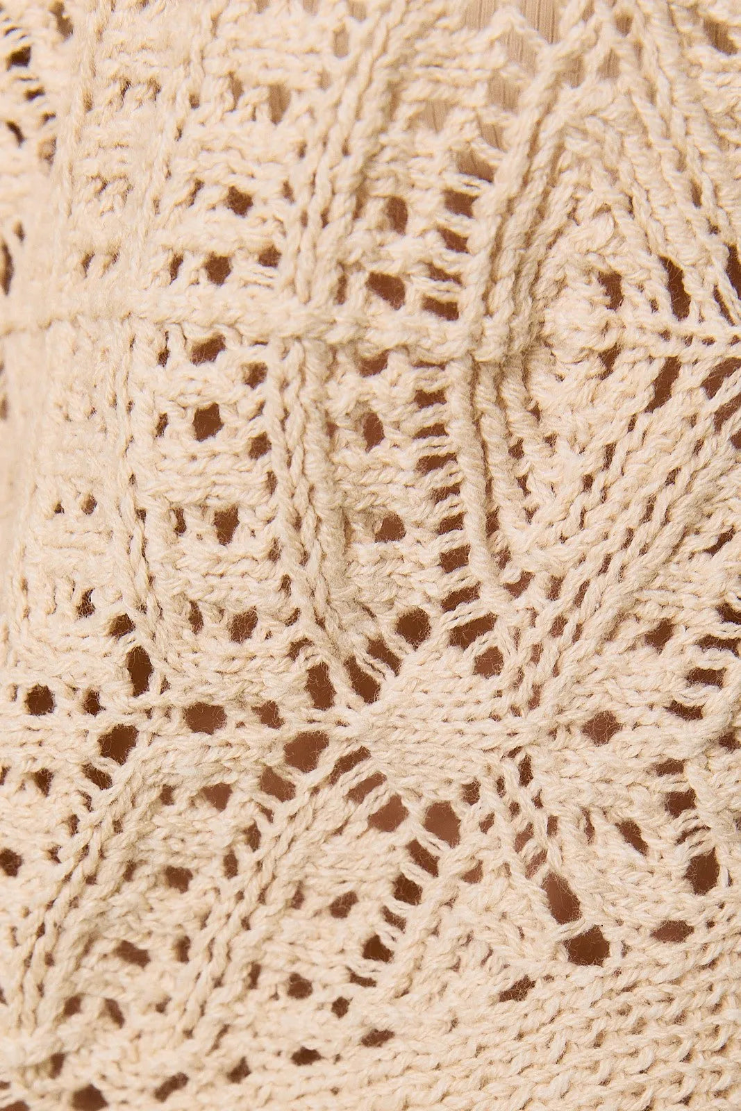 Cream-colored long sleeve crochet cardigan featuring intricately crocheted lace with a delicate openwork pattern