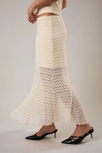 A cream-colored intricately crocheted mid rise midi half lined skirt with a flared hem and textured pattern
