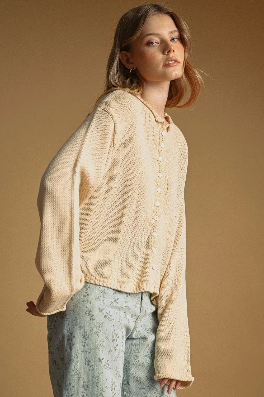Cream-colored easy knitted cardigan with button closure and slightly flared sleeves in loose-fitting knit design