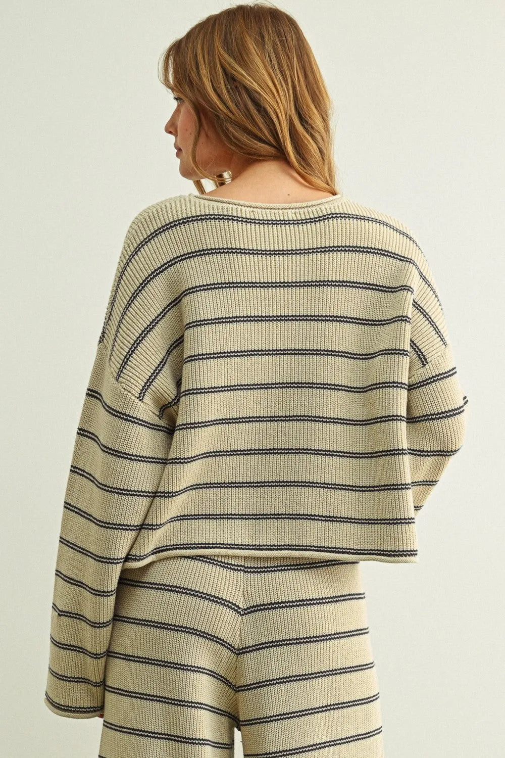 Cream-colored knit striped pattern long sleeve sweater with black horizontal stripes and relaxed cropped fit