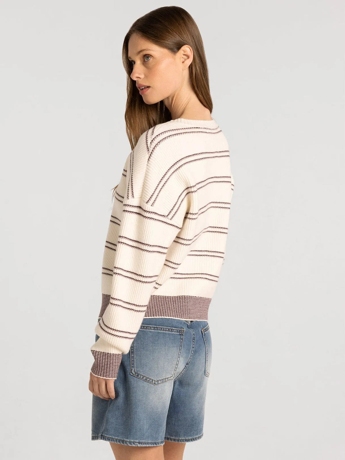 Cream-colored knit ely sweater by thread & supply with dark horizontal stripes and textured cuffs and waistband