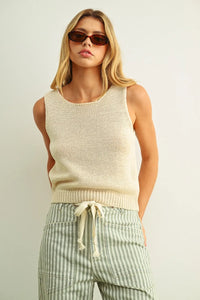 Cream-colored sleeveless roundneck knitted top with ribbed waistband and drawstring in soft yarn material