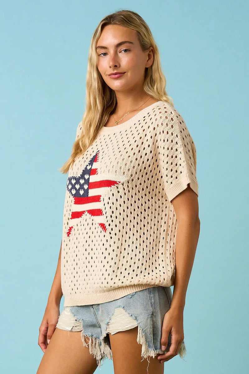 Cream-colored knitted sweater top with usa star patch featuring perforated star patch open knit design