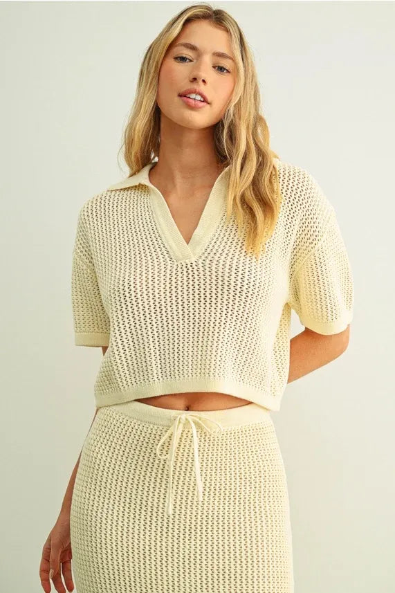 Cream-colored knitted two-piece set with crochet v-neck collar top and high-waisted skirt with drawstring waist