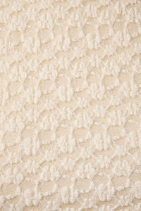 Cream-colored round neck lace sleeveless top featuring delicate raised floral lace fabric pattern