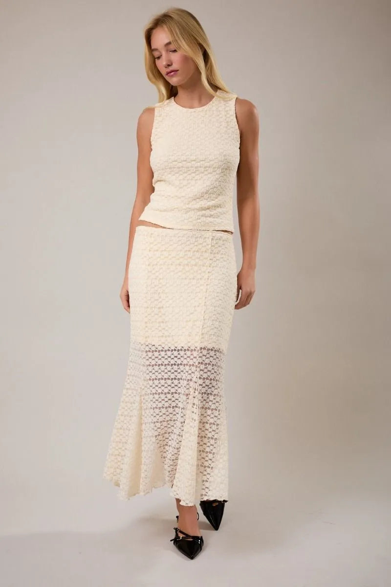 Cream-colored round neck lace sleeveless top with matching flared midi skirt featuring intricate openwork patterns