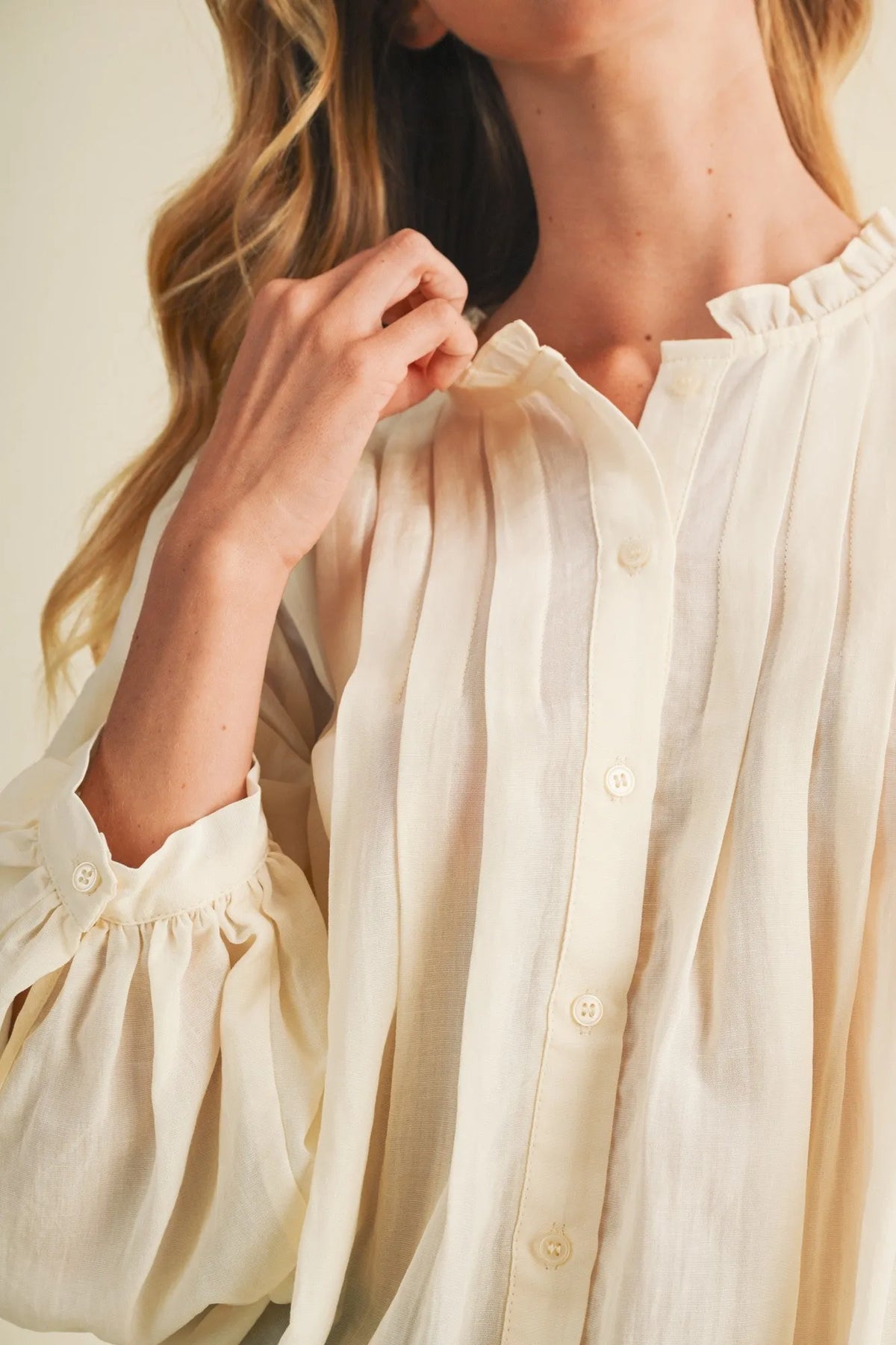 Cream-colored lightweight blouse with pintuck bib ruffle collar and puff sleeves for elegant wear