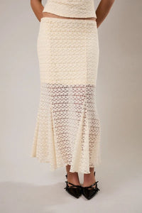 Cream-colored mid rise midi skirt with textured woven upper section and delicate lace detailing at the hem