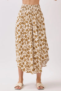 A cream-colored midi skirt with a smocked waistband and delicate gold floral pattern for elegant wear