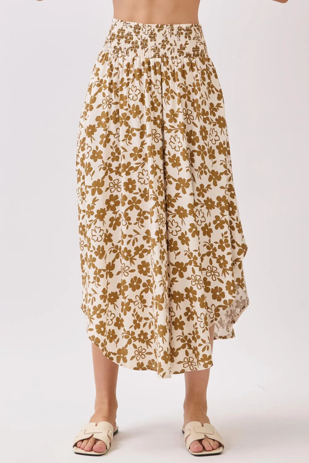 A cream-colored midi skirt with a smocked waistband and delicate gold floral pattern ideal for elegant wear