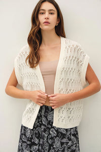 Cream-colored crochet knit boxy open cardigan with delicate lace pattern and ribbed trim in knitted material
