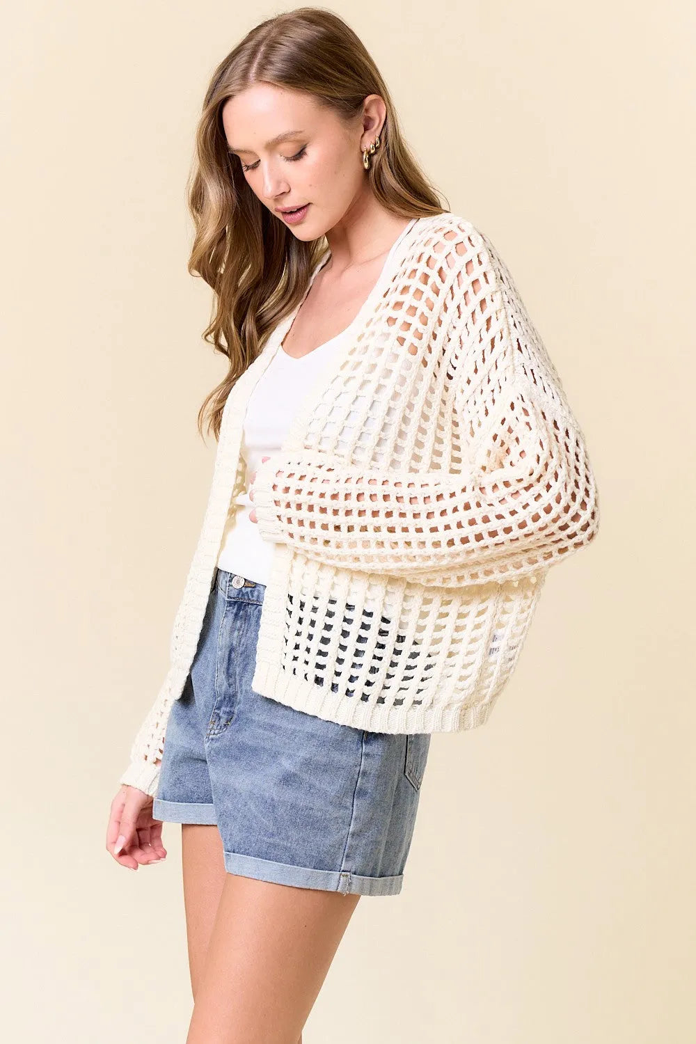 Cream-colored crochet fishnet cropped open cardigan with loose fit and wide sleeves in open-knit design