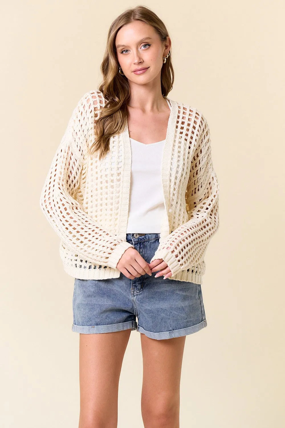 Cream-colored crochet fishnet cropped open cardigan with loose fit, open-knit material, and rolled cuffs
