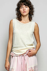 Cream-colored textured rib tank top with scalloped neckline and ruffled hem in ribbed knit fabric