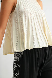 Cream-colored ribbed knit flared hem sleeveless top with peplum hem and delicate eyelet detailing