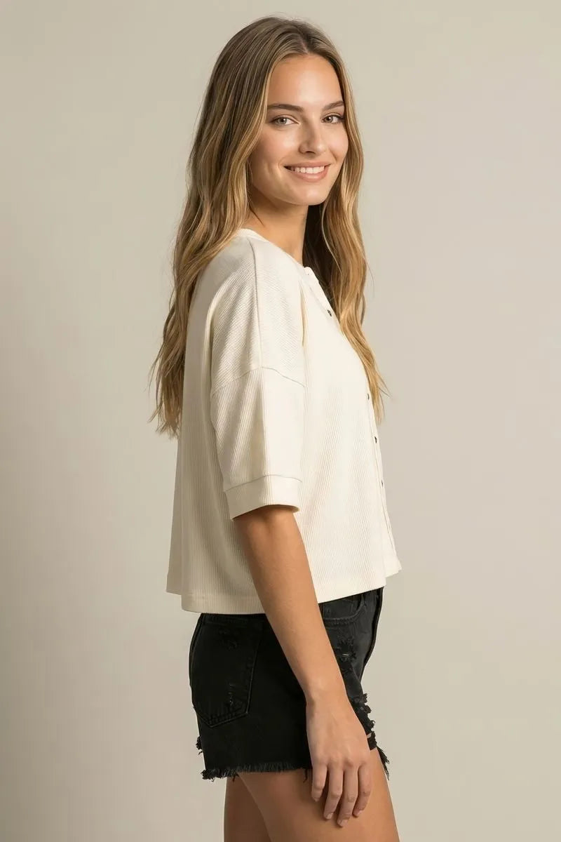 Cream-colored ribbed knit cropped top with short sleeves and button-front design for round neck boxy knit cardigan style