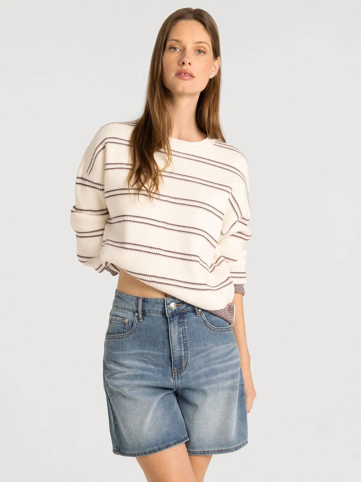 A cream-colored ribbed knit supply Ely sweater with black horizontal stripes and rolled-up sleeves