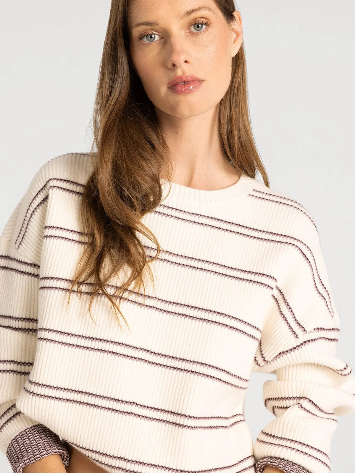 Cream-colored ribbed knit thread & supply ely sweater with dark brown stripes and textured cuffs in soft knit material